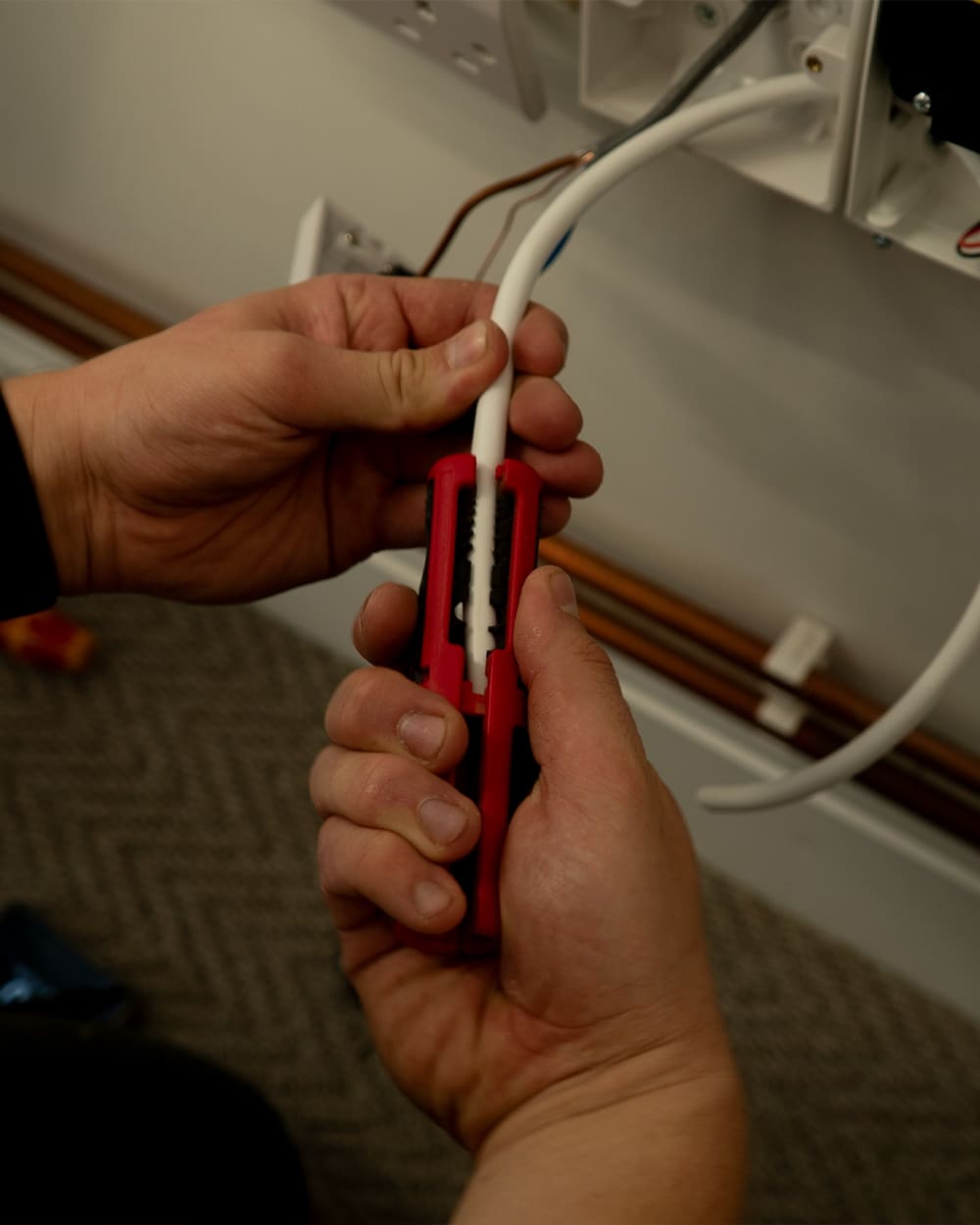 Engineer preparing and stripping cable during installation